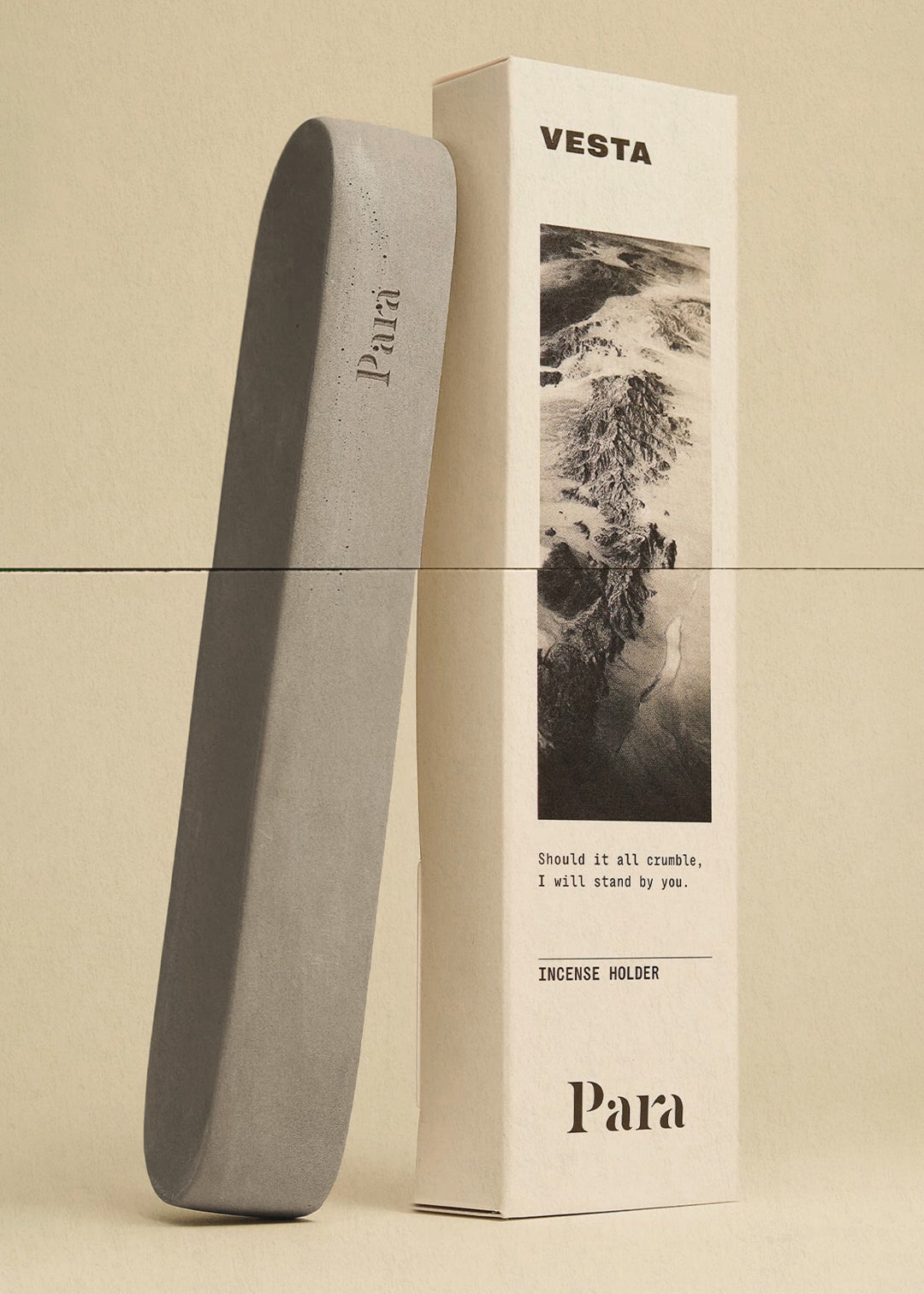 Vesta minimalist concrete incense holder in a natural gray finish Gray incense holder next to its packaging box on a beige background