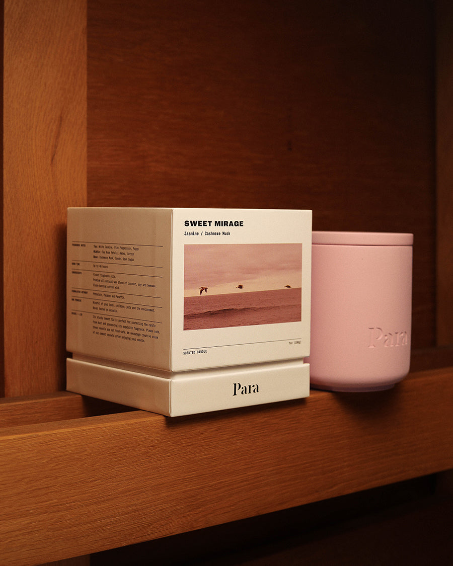 Pink candle and packaging labeled 'Sweet Mirage' on a wooden surface