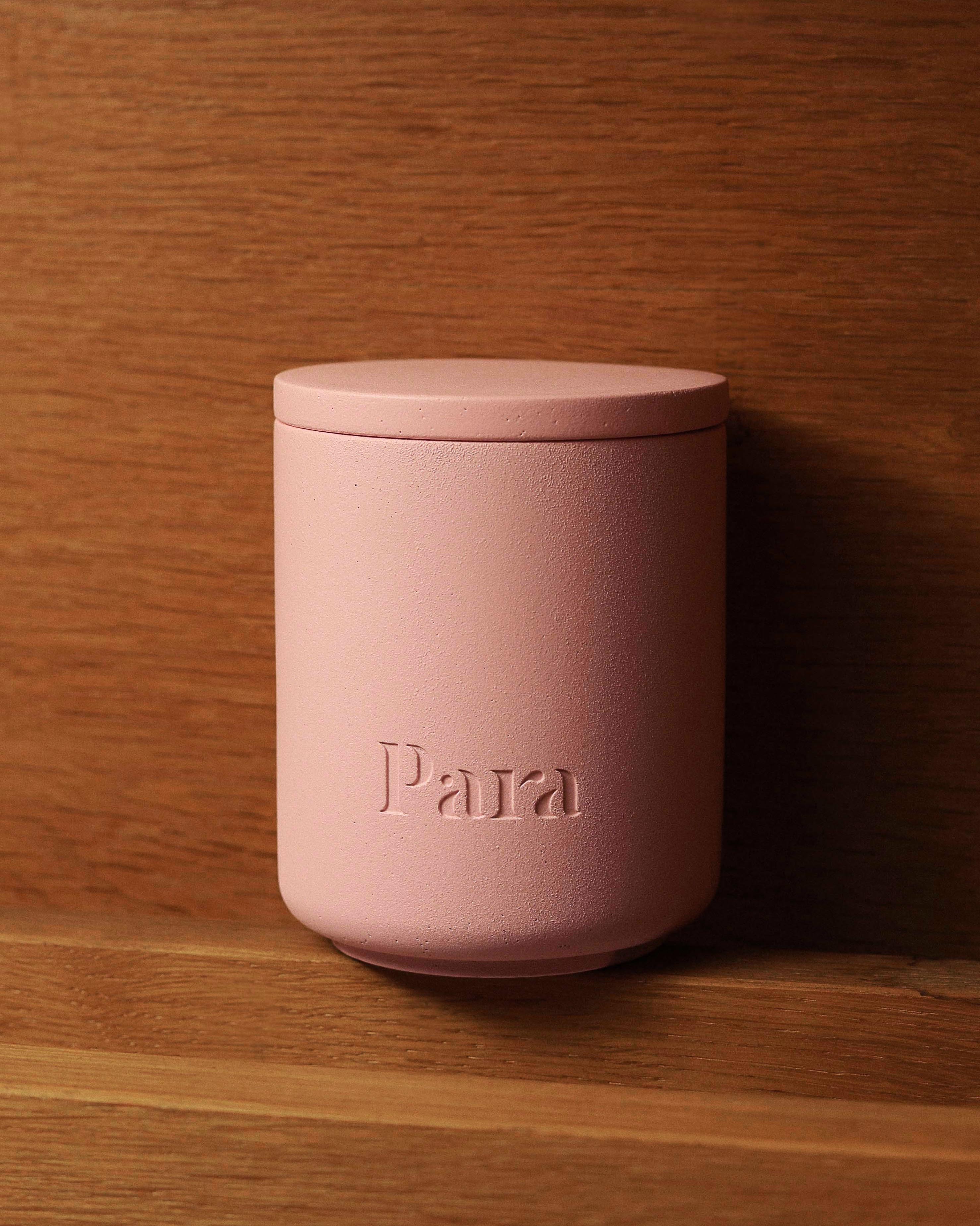 Pink container with 'Para' branding on a wooden surface Sweet Mirage pink concrete candle jar with lid by Para Home Studio