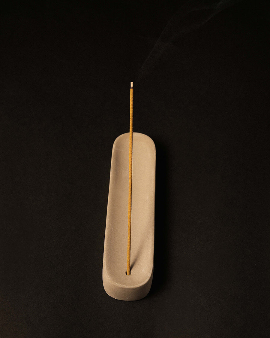 Incense stick in a concrete holder on a black background