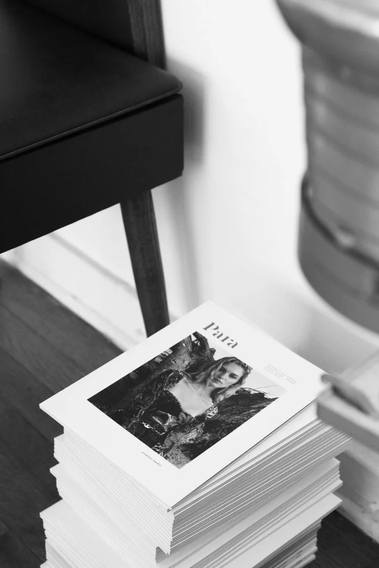 Stack of photo prints with a black and white image on a wooden surface.